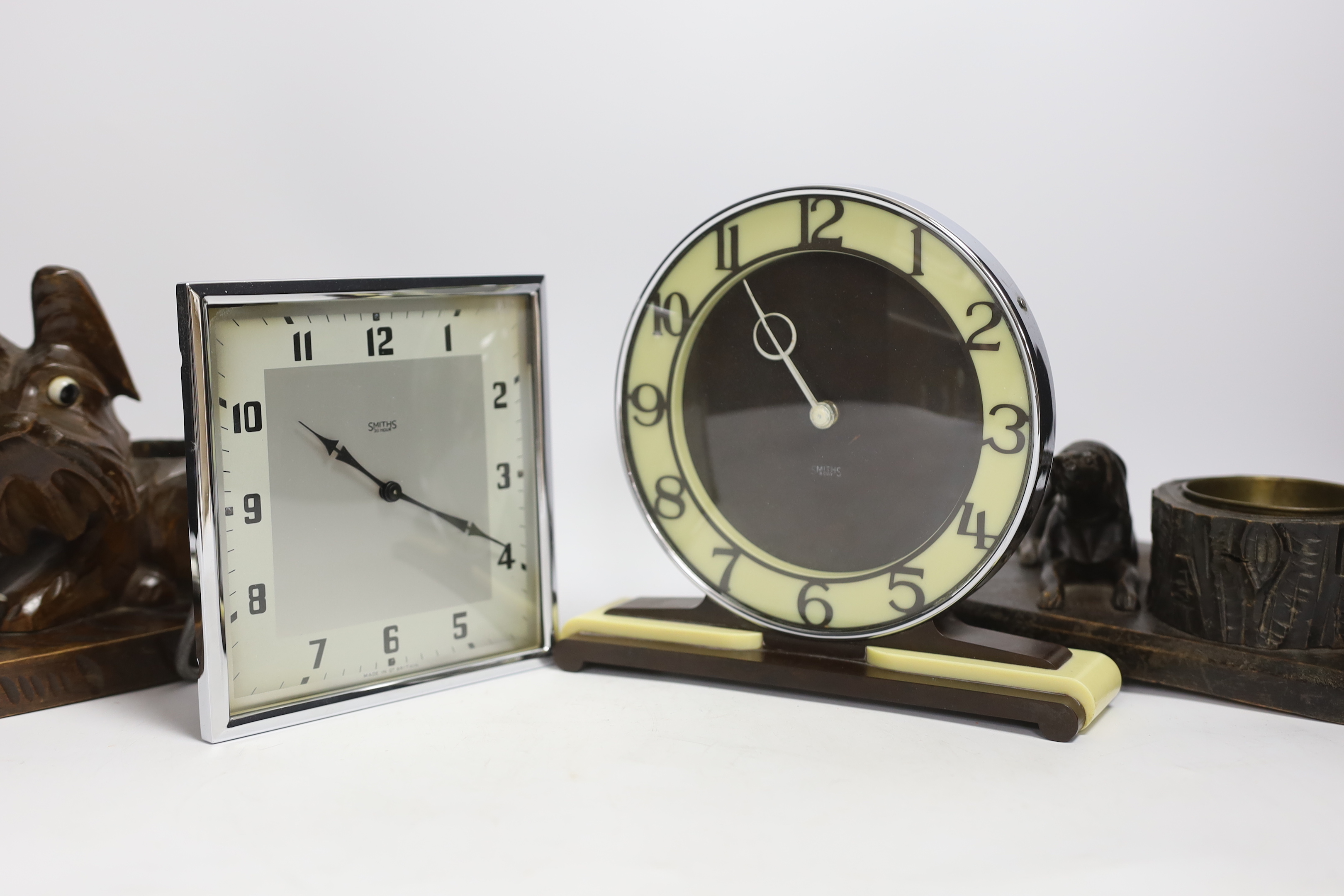 Two Art Deco clocks and two carved wood ‘dog’ ash trays, tallest 18cm
